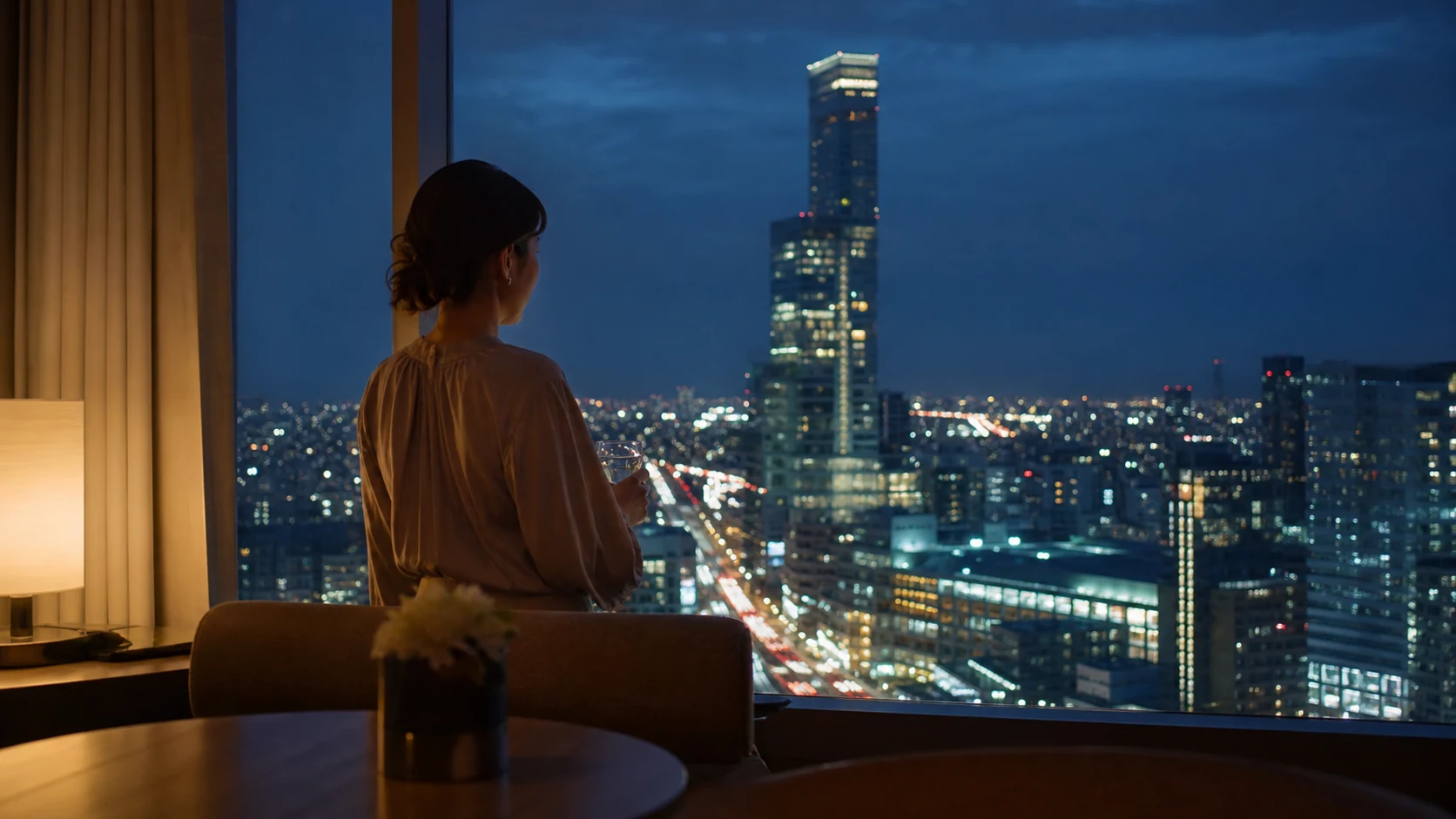 天王寺の高層ホテルで夜景を眺める日本人女性の後ろ姿
