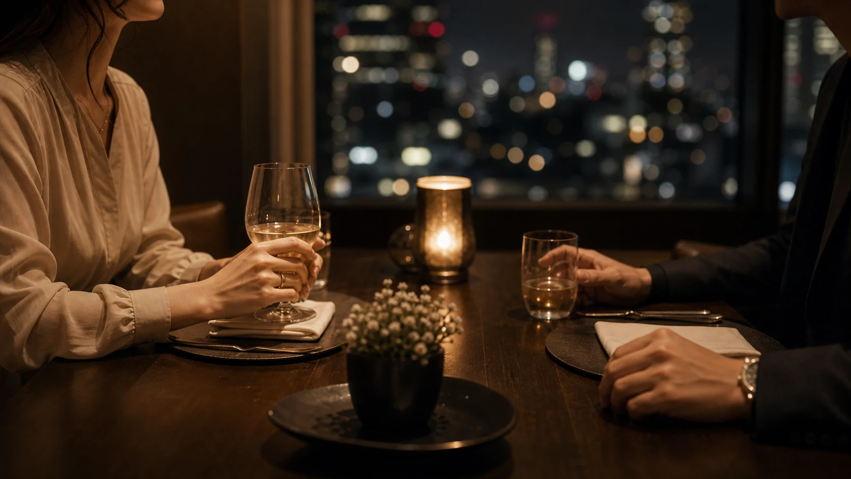 夜景を望むレストランで並んで食事を楽しむ男女